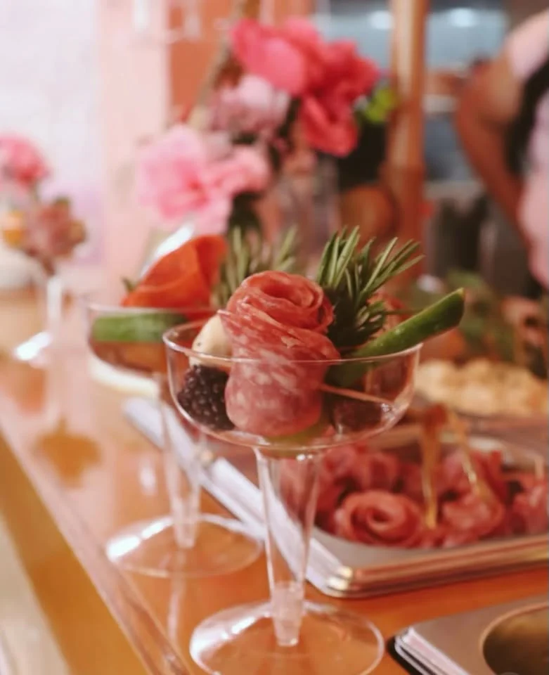 Individual charcuterie cup with salami, berries, herbs, and cheese