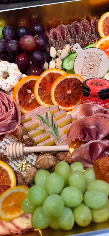 Close-up charcuterie arrangement with dried citrus, cheese, fruit, and cured meats