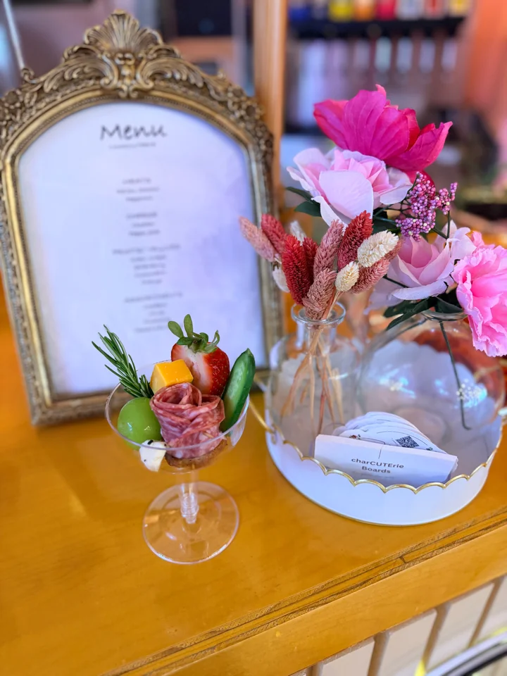 Place setting with framed menu, flowers, and a charcuterie cup