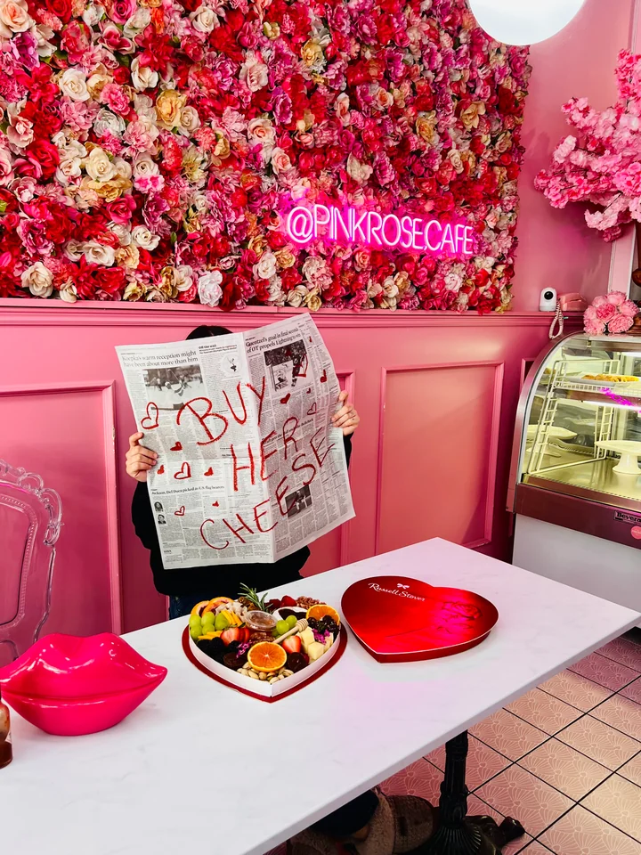 Pink event venue with a flower wall and charcuterie welcome table