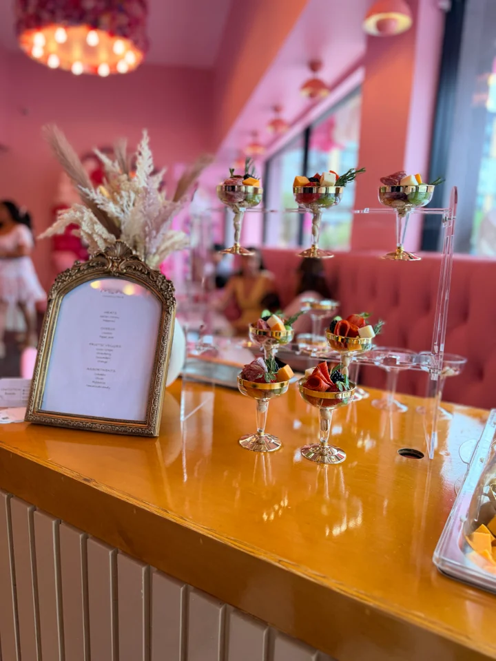 Event table with flowers and place settings inside a pink venue