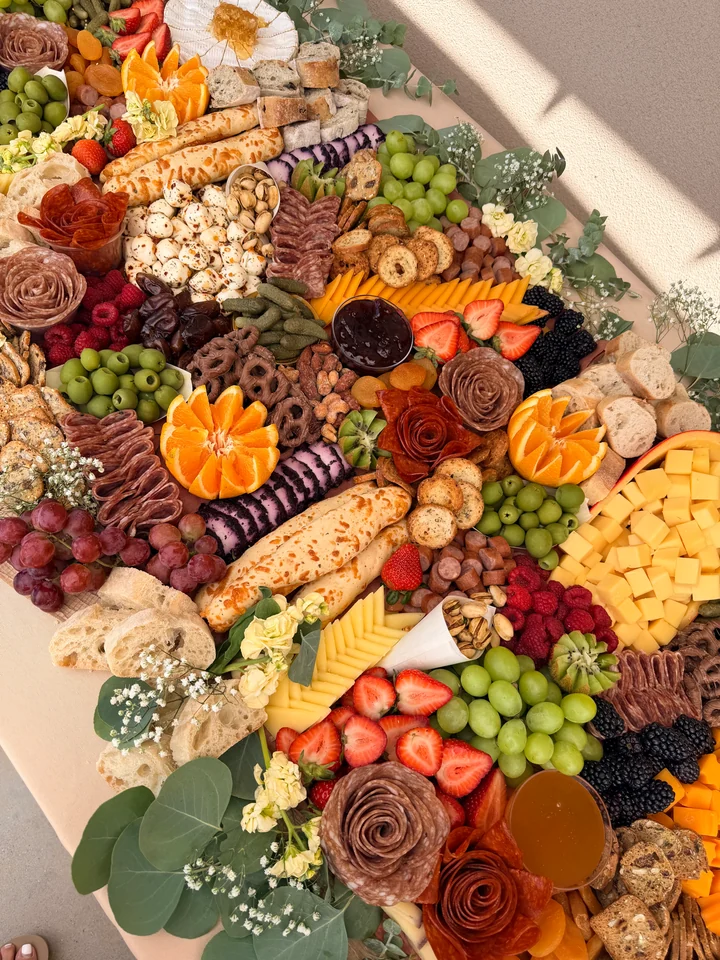 Large grazing display with fruit, cheese, bread, and salami roses