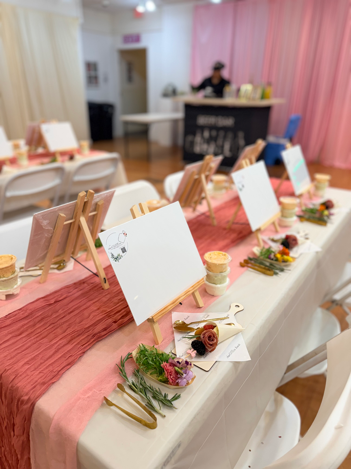 Private charcuterie workshop table set with easels, ingredients, florals, and supplies